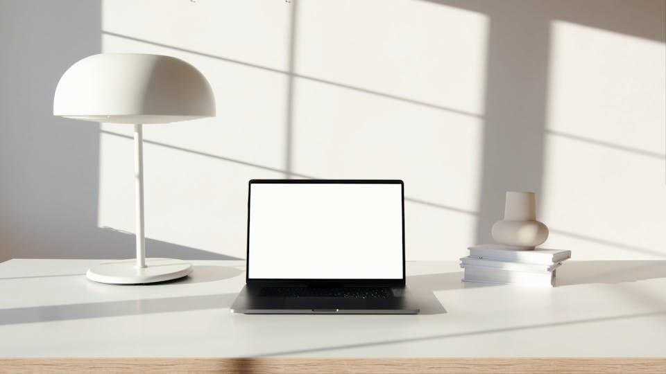 Laptop Computer On White Surface Near White Lampshade